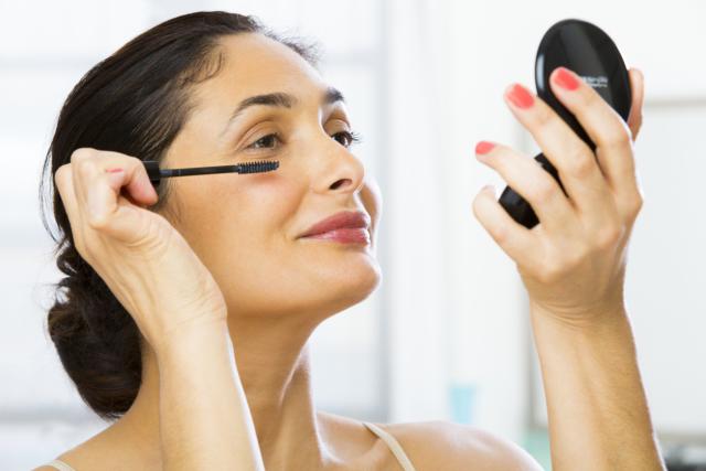 Mixed race woman applying makeup