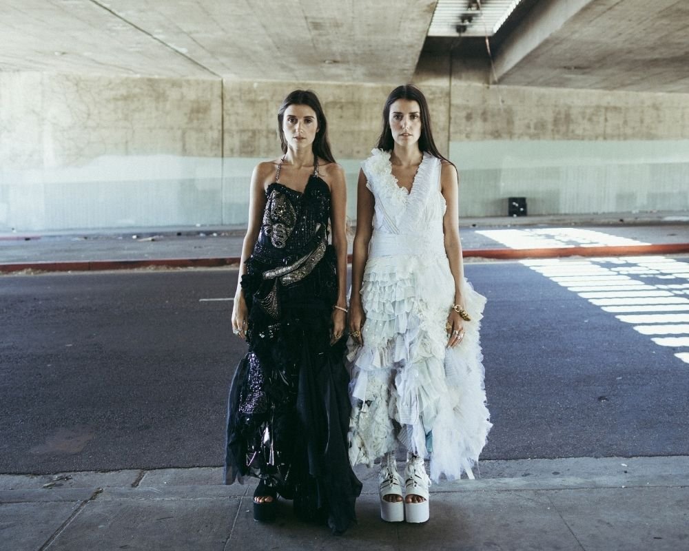 Jess and Stef Dadon, dressed fashionably in a carpark. 