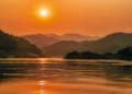 Serene sunset landscape over the Mekong River with scenic mountains in Bokeo Province, Laos.