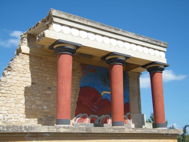 Explore the vibrant colors of ancient Knossos Palace with iconic Minoan columns and frescoes.